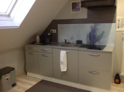 a small kitchen with a sink and a sink at le nid fleuri de Cravanche in Cravanche