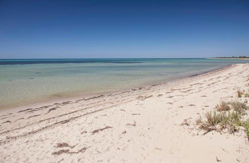 a sandy beach with the ocean in the background at Boardwalk in Quindalup