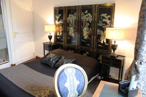 a bedroom with a bed and a large headboard at Résidence et Chambres d'Hôtes de La Porte d'Arras in Douai