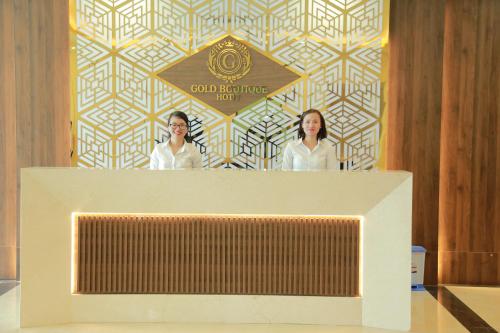 two women standing behind a podium in a room at Gold Boutique Hotel Danang in Da Nang
