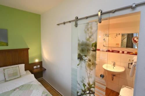 a bathroom with a shower and a bed and a sink at Wein-Träume in Thüngersheim