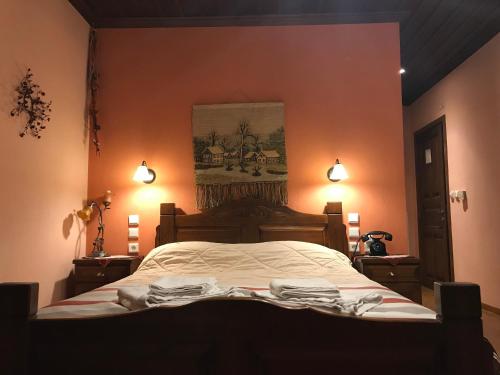 a bedroom with a bed with a painting on the wall at Archontiko Tsiboni in Elati Trikalon