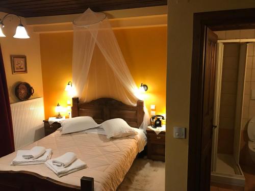 a bedroom with a bed with two towels on it at Archontiko Tsiboni in Elati Trikalon