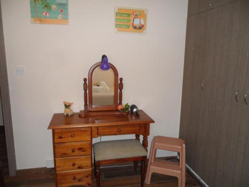 a wooden dressing table with a mirror and a chair at SUNSHINE APTS, TWO BEDROOM , FREE INTERNET, No 3 in Ayia Napa