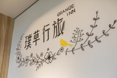 a wall with chinese writing and a yellow bird on it at Grange Inn in Taitung City