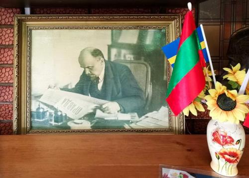 a picture of a man reading a newspaper on a table at Like Home Hostel & TOURS in Tiraspol