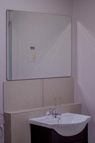 a bathroom with a sink and a large mirror at 314 on Clark Guest House in Pretoria
