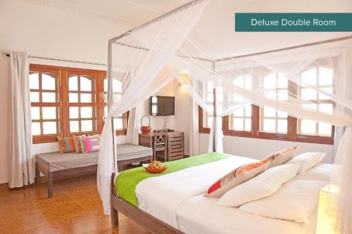 a bedroom with a canopy bed with a desk at The Pavilion in Phnom Penh