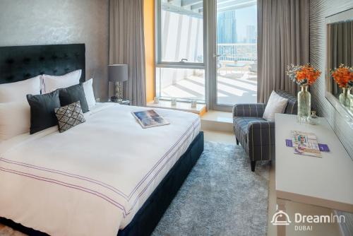 Cette chambre comprend un grand lit et une fenêtre. dans l'établissement Dream Inn Apartments - 29 Boulevard Private Terrace, à Dubaï