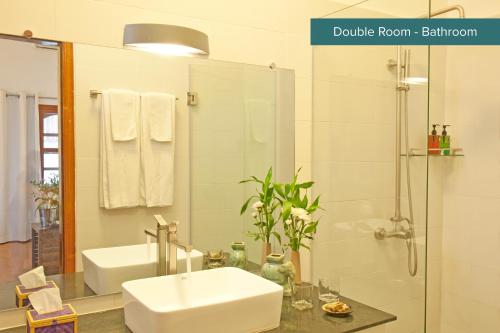 a bathroom with a white sink and a shower at The Pavilion in Phnom Penh