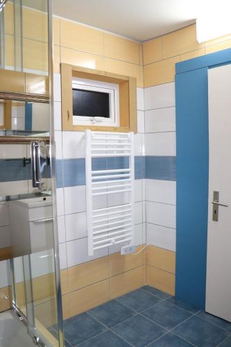 a bathroom with a glass shower with a window at Casa o Futuro in Alcobaça