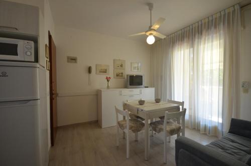 a kitchen and living room with a table and chairs at Appartamenti Alisei e Cristina in Bibione