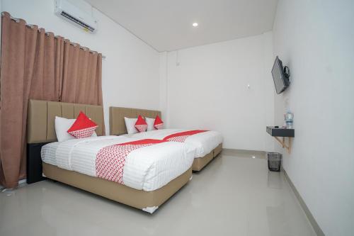 Ένα ή περισσότερα κρεβάτια σε δωμάτιο στο OYO 443 Hotel Barlian