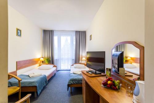 a hotel room with two beds and a mirror at Albatros Medical SPA in Mielno
