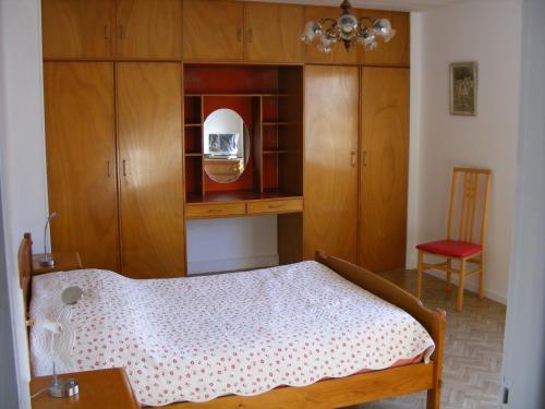 um quarto com uma cama, armários de madeira e uma cadeira em au sapin des vosges em Saint-Étienne-lès-Remiremont