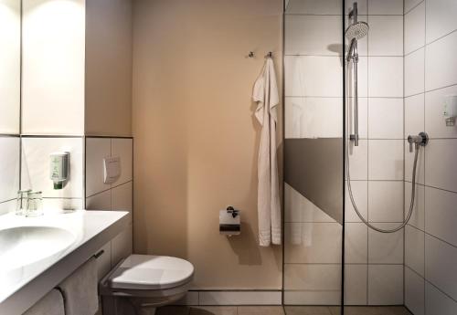 uma casa de banho com um chuveiro, um WC e um lavatório. em Best Western Plus Residenzhotel Lüneburg em Lüneburg