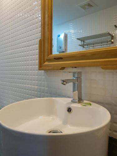 a white sink in a bathroom with a mirror at Montagne Regency in Kampot