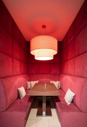 a red dining room with a table and a light at Hotel Orangerie in Vienna