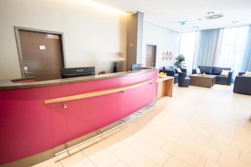 a lobby of a hospital with a red counter at Hotel Orangerie in Vienna