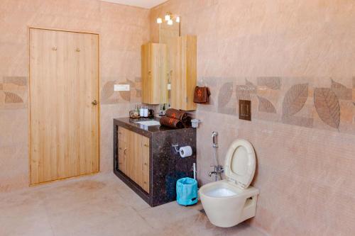 a bathroom with a toilet and a sink at SaffronStays La Casa Maestro, Kashid - spanish-style luxury villa near Kashid Beach in Kashid