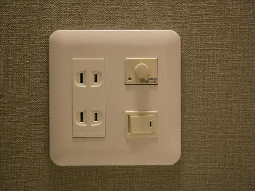 a white light switch on a wall at THE WARDROBE Hotel Shimokitazawa in Tokyo
