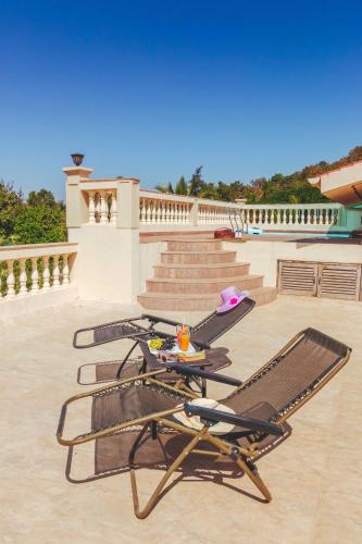 a patio with two lounge chairs and a table at SaffronStays La Casa Maestro, Kashid - spanish-style luxury villa near Kashid Beach in Kashid