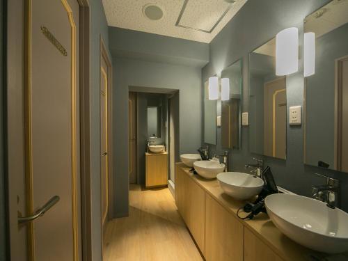 a bathroom with three sinks and two mirrors at THE WARDROBE Hotel Shimokitazawa in Tokyo