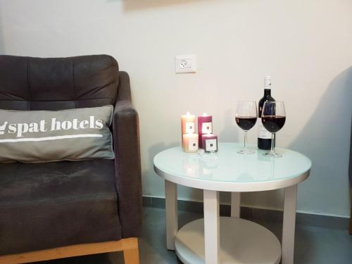 a table with two glasses of wine and a chair at Spat Hotel Ashdod in Ashdod