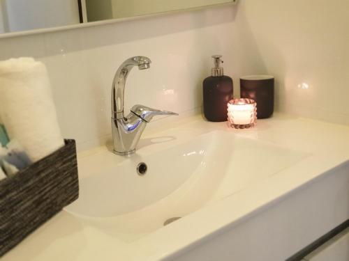a bathroom sink with a faucet and a candle at Spat Hotel Ashdod in Ashdod
