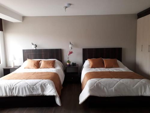 une chambre avec deux lits dans une pièce dans l'établissement Hotel La Algodonera, à Ambato