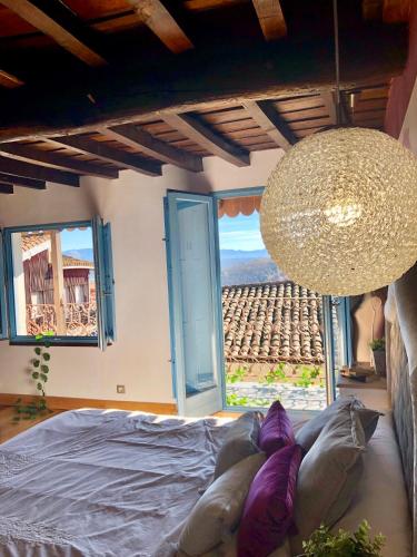 a bedroom with a bed and a large chandelier at Casa Rural Cabo la Aldea in Mogarraz