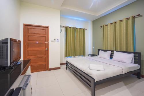 a bedroom with a bed and a television in it at Suphan Lake Hometel in Lat Krabang