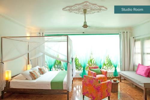 a bedroom with a canopy bed and a chair at The Pavilion in Phnom Penh