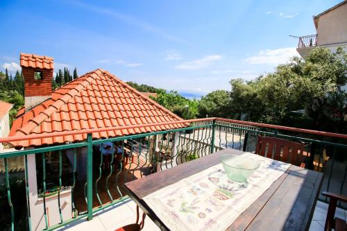 a balcony with a wooden table on a deck at Apartment Ida in Trpanj