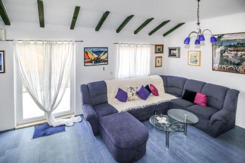 a living room with a blue couch and a table at Apartment Ida in Trpanj