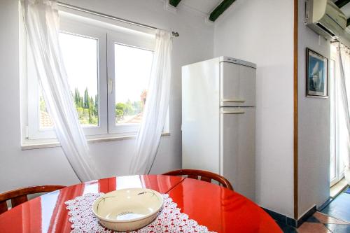 a kitchen with a red table and a refrigerator at Apartment Ida in Trpanj