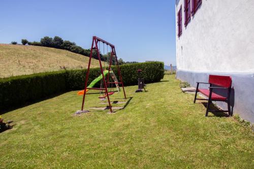a swing set in the grass next to a building at Casa Katton in Etxalar