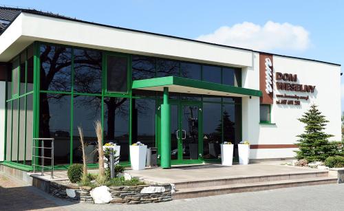 a store front with a green and white building at DOM WESELNY ,, ANNA'' in Warlubie