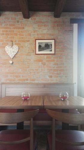 a wooden table with two chairs and a heart on a brick wall at Agriturismo San Gallo in Strassoldo