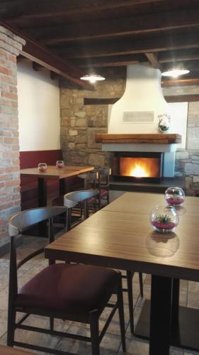a restaurant with tables and chairs and a fireplace at Agriturismo San Gallo in Strassoldo