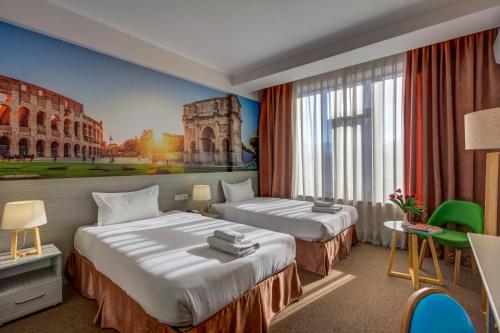a hotel room with two beds and a painting of the coliseum at Hotel Bridges Bishkek in Bishkek