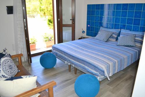 Schlafzimmer mit einem Bett mit blauer Bettwäsche und blauen Akzenten in der Unterkunft B&B La Casa Bianca di Porto Conte in Porto Conte