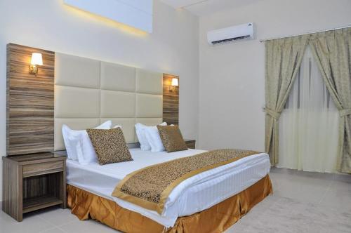 a bedroom with a large bed in a room at منازل بلقيس للشقق المخدومة فرع الشفاء in Hail