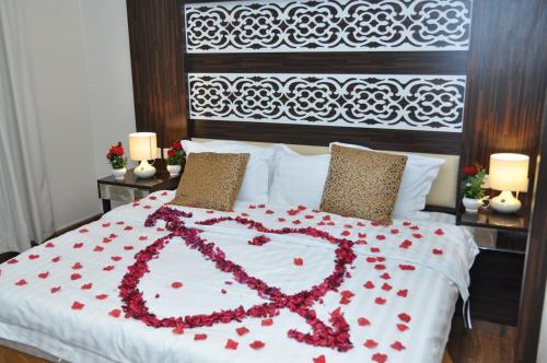 a bed with a heart made out of red roses at منازل بلقيس للشقق المخدومة فرع الشفاء in Hail
