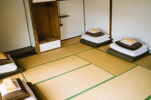 a room with four mattresses on the floor at Onsen Guesthouse HAKONE TENT in Hakone