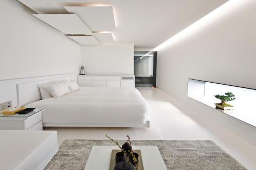 a white bedroom with a bed and a couch at MOGANA in Kyoto