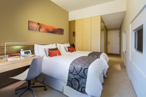 a hotel room with a large bed and a desk at Park Avenue Rochester in Singapore