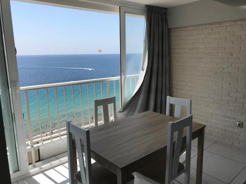 a dining room with a table and a view of the ocean at Levante Trip - Family Apartments in Benidorm
