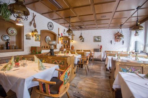 a restaurant with tables and chairs with white table cloth at Hotel Hirsch in Bad Peterstal