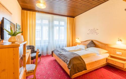 a hotel room with a bed and a window at Hotel Post Hönigwirt in Kirchschlag